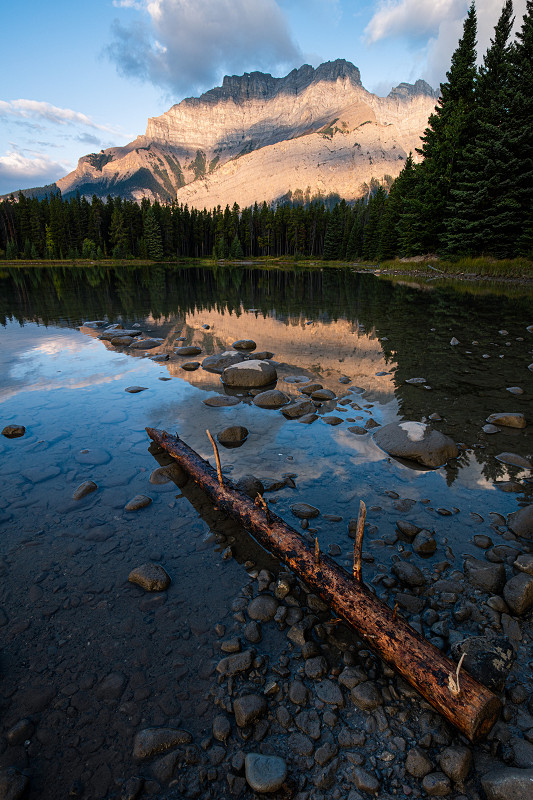 Dawn again - The sun beams across the side of Cascade Mountain in Banff National Park, Alberta, Canada